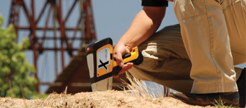 Olympus Innov-X DELTA handheld XRF analyzer analyzing soil in-situ.
